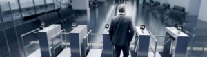 man walking through a row of covid-19 touchless turnstiles with temperature sensors facial recognition for hands-free operation